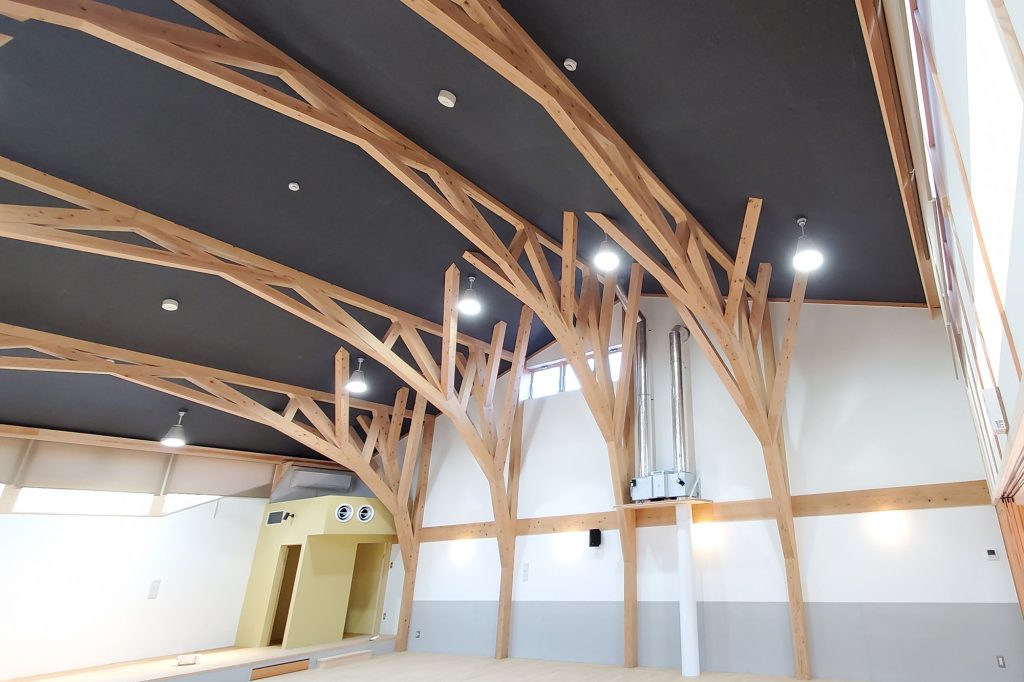 認定こども園のホールの天井一面に施工したチャコールグレーの吸音パネル