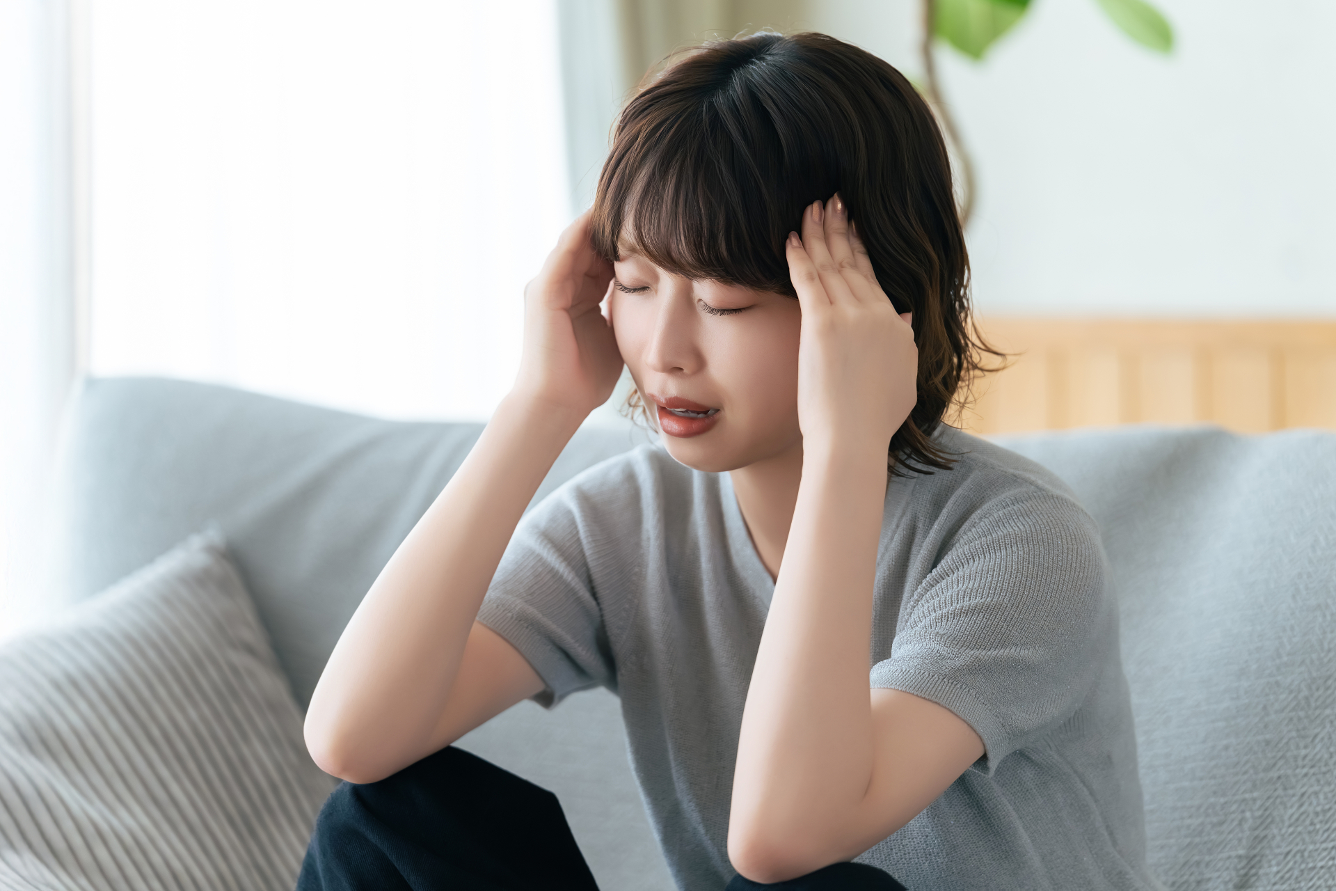 犬の鳴き声など室内の騒音に困り頭を抱える女性