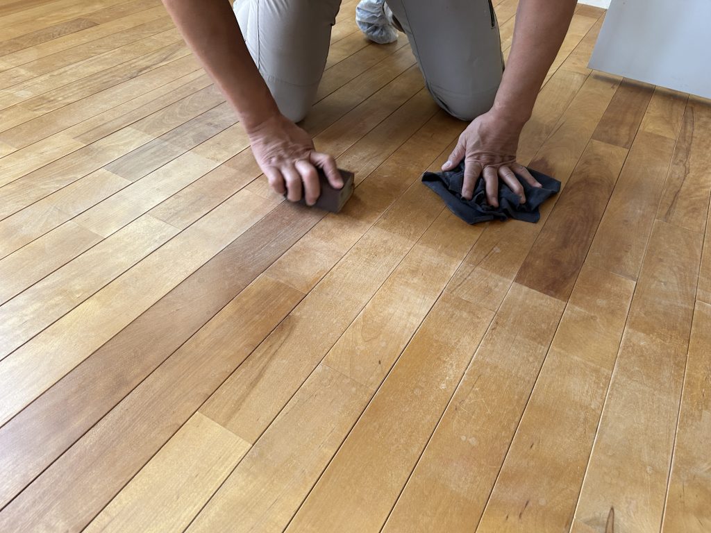 床にひざをついて、手作業で表面をていねいに整えているところ